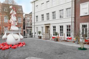 a sculpture of a snowman with red flowers in a courtyard at Boutique Hotel Jeroen in Den Bosch