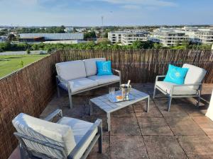 a patio with two chairs and a couch and a table at 360 degrés sur la rochelle in La Rochelle