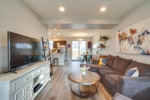 a living room with a large flat screen tv at Suburban Denver Home with Fire Pit and Shuffleboard! in Denver