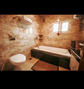 La salle de bains est pourvue de toilettes, d'une baignoire et d'un lavabo. dans l'établissement The Gardenia7, à Srinagar