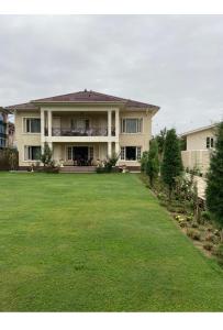 une grande maison avec une grande pelouse devant elle dans l'établissement The Gardenia7, à Srinagar