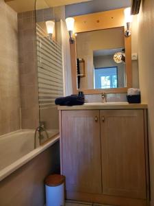 a bathroom with a sink and a tub and a mirror at Résidence les aloès T2 , idéal 2 adultes 2 enfants à 2 minutes de la mer in Cerbère