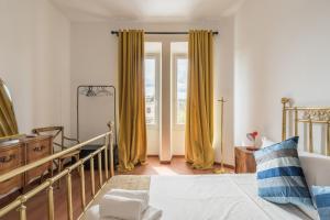 sypialnia z żółtymi zasłonami, łóżkiem i oknem w obiekcie Stylish Pigneto Apartment w Rzymie