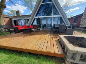 a wooden deck with chairs and tables on a house at Sandy Beach Retreat on Big Spirit Lake in Spirit Lake