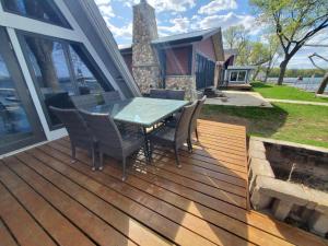 a wooden deck with a table and chairs on a house at Sandy Beach Retreat on Big Spirit Lake in Spirit Lake +38 photos