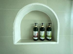 three bottles of wine sitting on a shelf in a wall at มินิมอลโฮลเทล in Ban Khlong Khachen