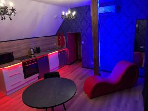 a living room with a table and chairs and purple lighting at Love room avec jacuzzi privé in Bonnétable