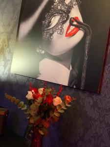 Una foto di una donna con una maschera e un telefono di Love room avec jacuzzi privé a Bonnétable