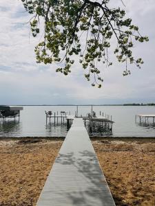a dock in the water with a table and benches at Sandy Feet Retreat on Big Spirit Lake in Spirit Lake