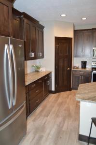 una cocina con electrodomésticos de acero inoxidable y armarios de madera en Bridges Bay Resort Bayside Building 203 en Arnolds Park