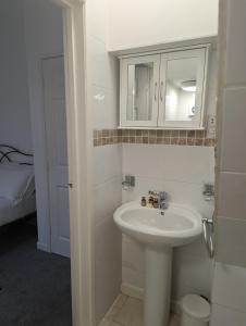 a white bathroom with a sink and a mirror at Bridge Terrace E in Southampton