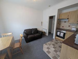 a living room with a leather couch and a kitchen at Bridge Terrace E in Southampton