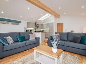 a living room with two blue couches and a table at 7 Valley View in Looe