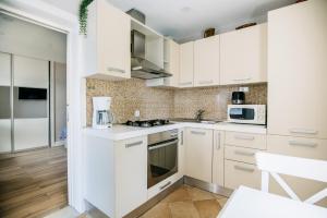 una cocina blanca con armarios y electrodomésticos blancos en SEA PEARL APARTMENTS by DuHomes, en Dubrovnik