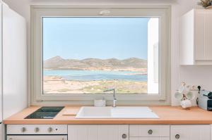 a kitchen with a large window over a sink at Antiparos Thea in Antiparos