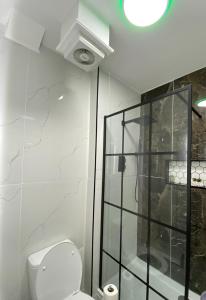 een badkamer met een toilet en een glazen douche bij Station House in Batley