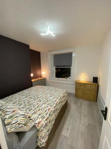 1 dormitorio con cama y ventana en Station House, en Batley