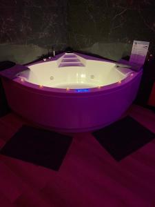 a purple bath tub sitting in a room at Love room avec jacuzzi privé in Bonnétable