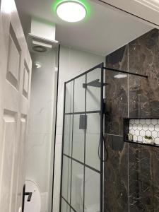 a shower with a glass door in a bathroom at Station House in Batley