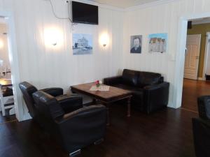 a living room with a couch and a table and chairs at Badeland Gjestegård in Raufoss