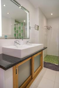 La salle de bains est pourvue d'un lavabo blanc et d'un miroir. dans l'établissement Casa Monte Cristo Too, à Lagos
