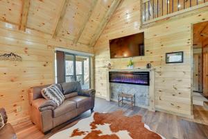 a living room with a couch and a fireplace at Riverside Beattyville Cabin with Kayaks and Fire Pit! in Beattyville