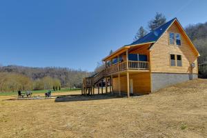 a large wooden house on top of a hill at Riverside Beattyville Cabin with Kayaks and Fire Pit! in Beattyville