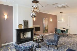 a living room with a fireplace and chairs and a table at Boutique Hotel Jeroen in Den Bosch