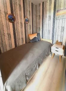 a bedroom with a large bed with a wooden wall at Huus an´t Diek in Wangerland