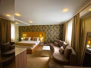 a hotel room with a bed and a couch at Hotel Deluxe in Tirana