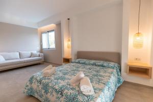 una camera da letto con un letto e asciugamani di Molo Brin Rooms & Suites a Olbia
