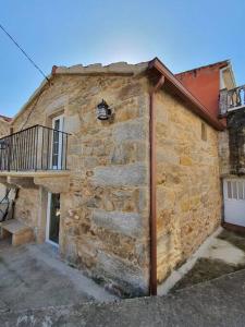 a stone building with a balcony on the side of it at Casa con encanto en Laxe in Laxe