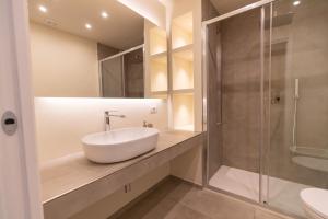 uma casa de banho com um lavatório e um chuveiro em Molo Brin Rooms & Suites em Olbia