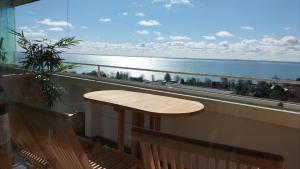 a table on a balcony with a view of the ocean at Loft mit Meerblick in Strandnähe in Sierksdorf