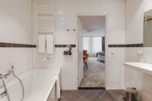a white bathroom with a tub and a sink at Boutique Hotel Jeroen in Den Bosch +55 photos