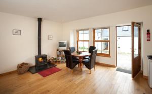 a living room with a table and chairs and a fireplace at The Steading, Back Borland Holiday Cottages in Stirling