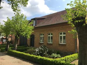 a brick house with trees in front of it at Lindenhof, Wohnung 1, Giebel in Vipperow