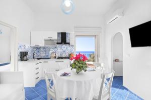a kitchen with a table with a vase of flowers on it at BlueVista Dreamscape Home -Terrace Jacuzzi/Hot Tub in Positano