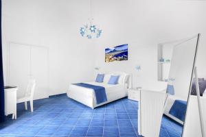 a bedroom with a bed and a blue tile floor at BlueVista Dreamscape Home -Terrace Jacuzzi/Hot Tub in Positano
