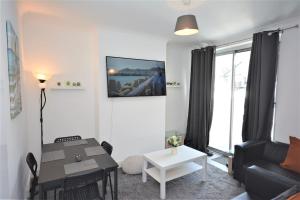 a living room with a table and a couch at 4 Bedroom House in East London in London