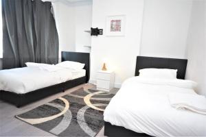 倫敦的住宿－4 Bedroom House in East London，卧室内两张并排的床