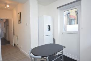 a white room with a chair and a window at 4 Bedroom House in East London in London