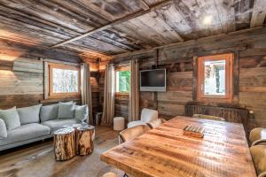 a living room with a table and a couch at Exceptional flat in a chalet - Megève - Welkeys in Megève