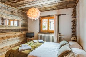 a bedroom with a bed and a chandelier at Exceptional flat in a chalet - Megève - Welkeys in Megève