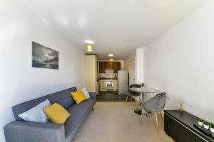a living room with a blue couch and a table at Luxe 1 bed flat 5 mins to Stratford - Free Parking in London