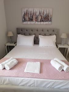 un grande letto bianco con due asciugamani sopra di Nicole Apartment a Perdhika