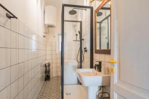 a white bathroom with a sink and a shower at Stylish Pigneto Apartment in Rome
