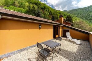 a patio with chairs and a table and a building at Bologna House in Perledo