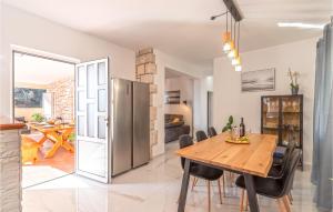 a kitchen and dining room with a wooden table and chairs at Beautiful Home In Gradina With Kitchen in Vela Luka