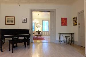 a living room with a piano and a room with a table at 1830’s Historic Merchant House on the park LES in New York
